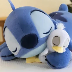 Peluche Stitch allongée avec son canard
