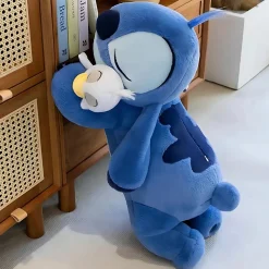 Peluche Stitch allongée avec son canard